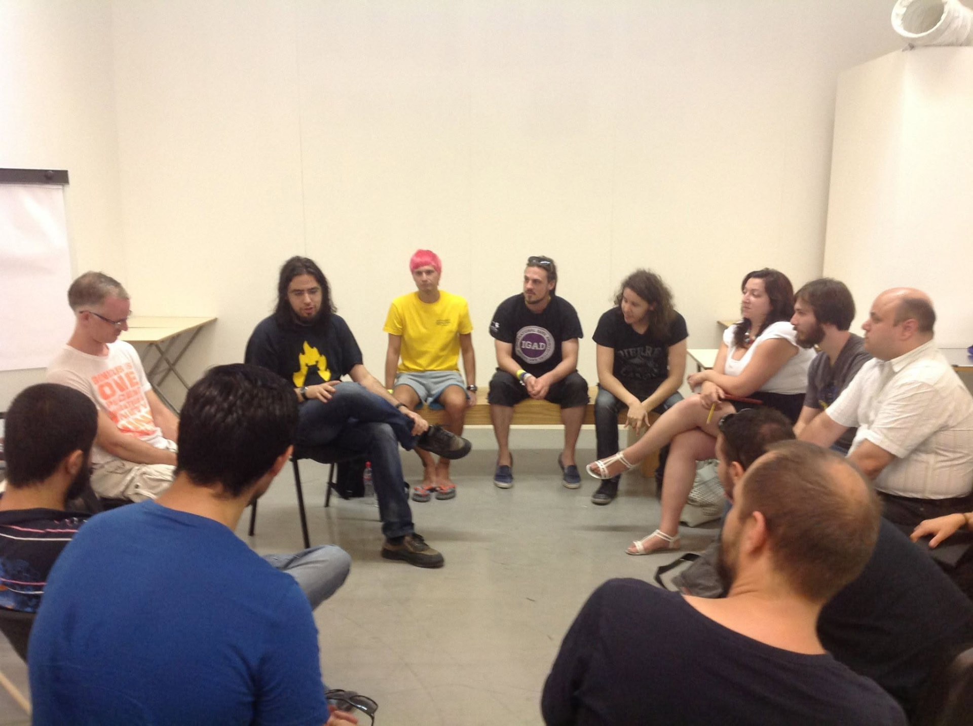 A larger circle of participants talking together in a bright room